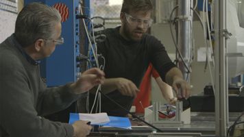 Student and Professor Working on Machine